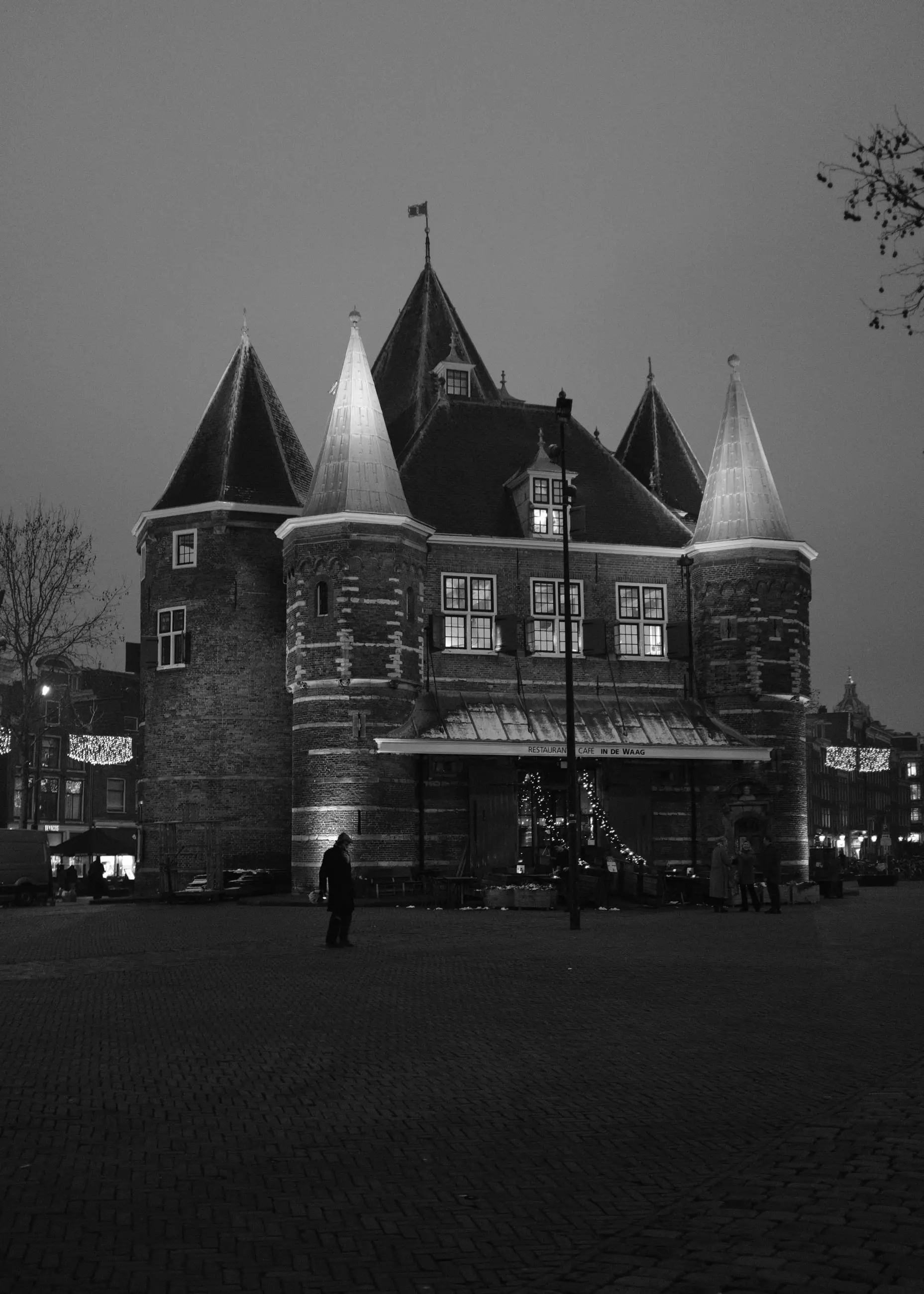 De Waag at night, a figure crossing the square