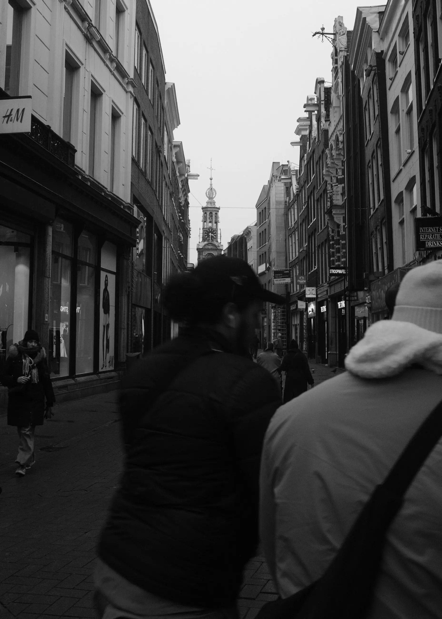 Two figures in the foreground blocking the view of a street