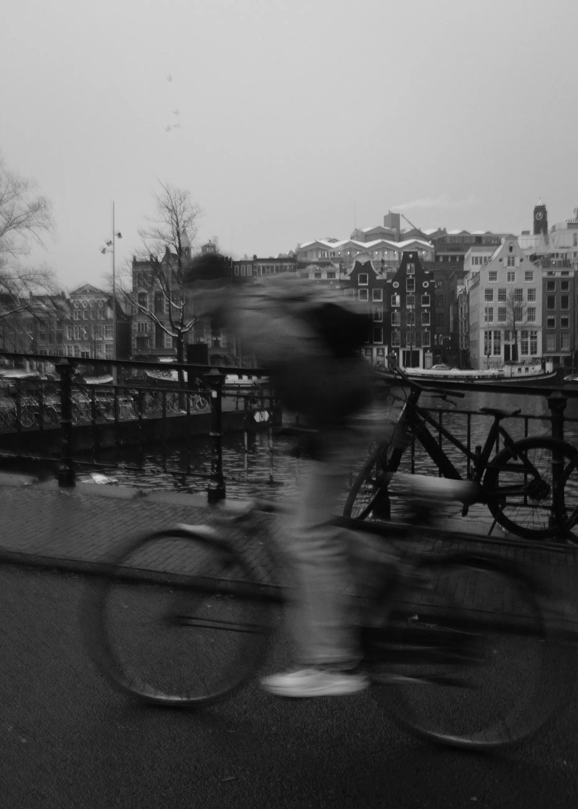 A cyclist in motion past a street lamp