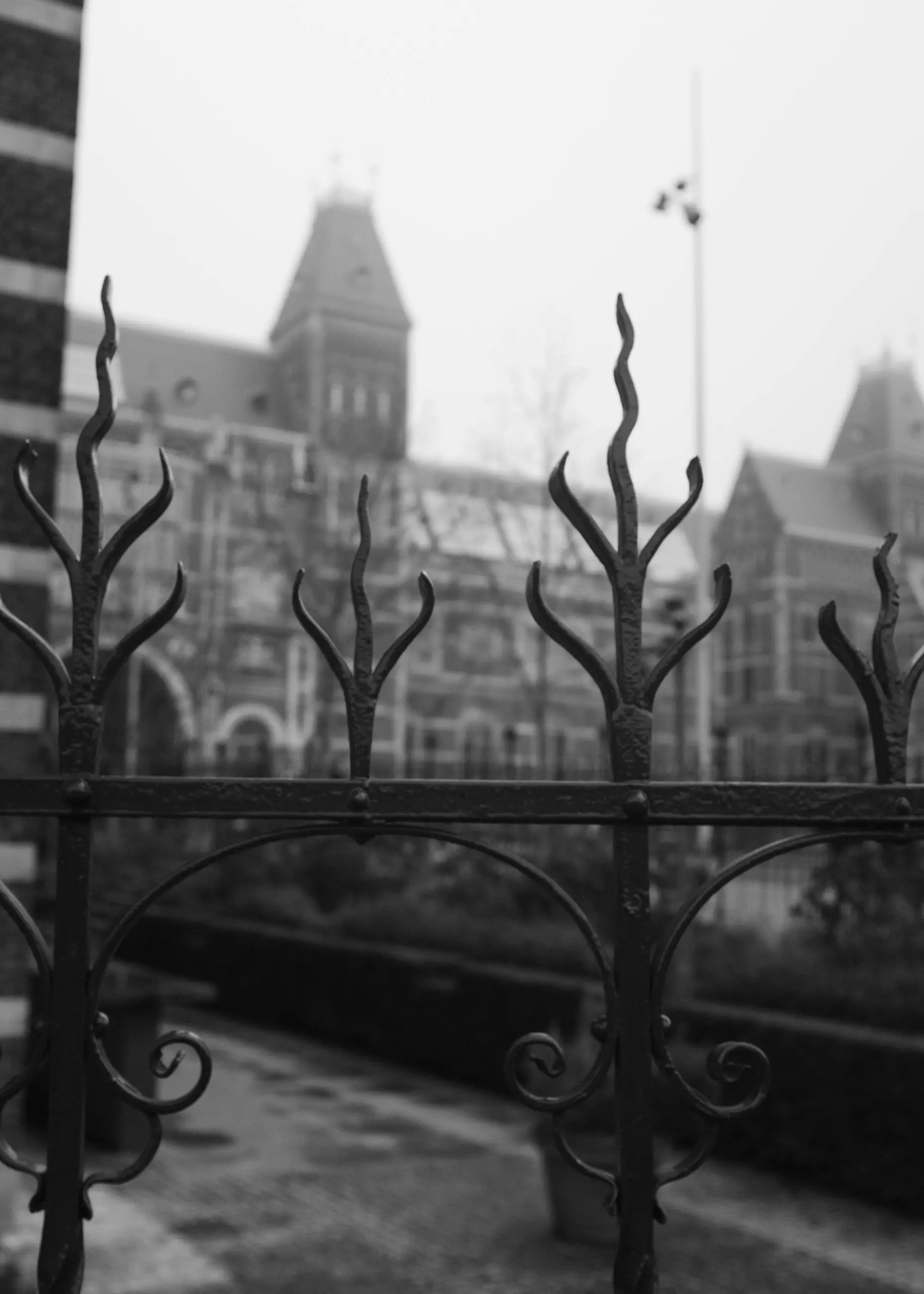 Wrought-iron fence tips in the foreground and a museum façade beyond