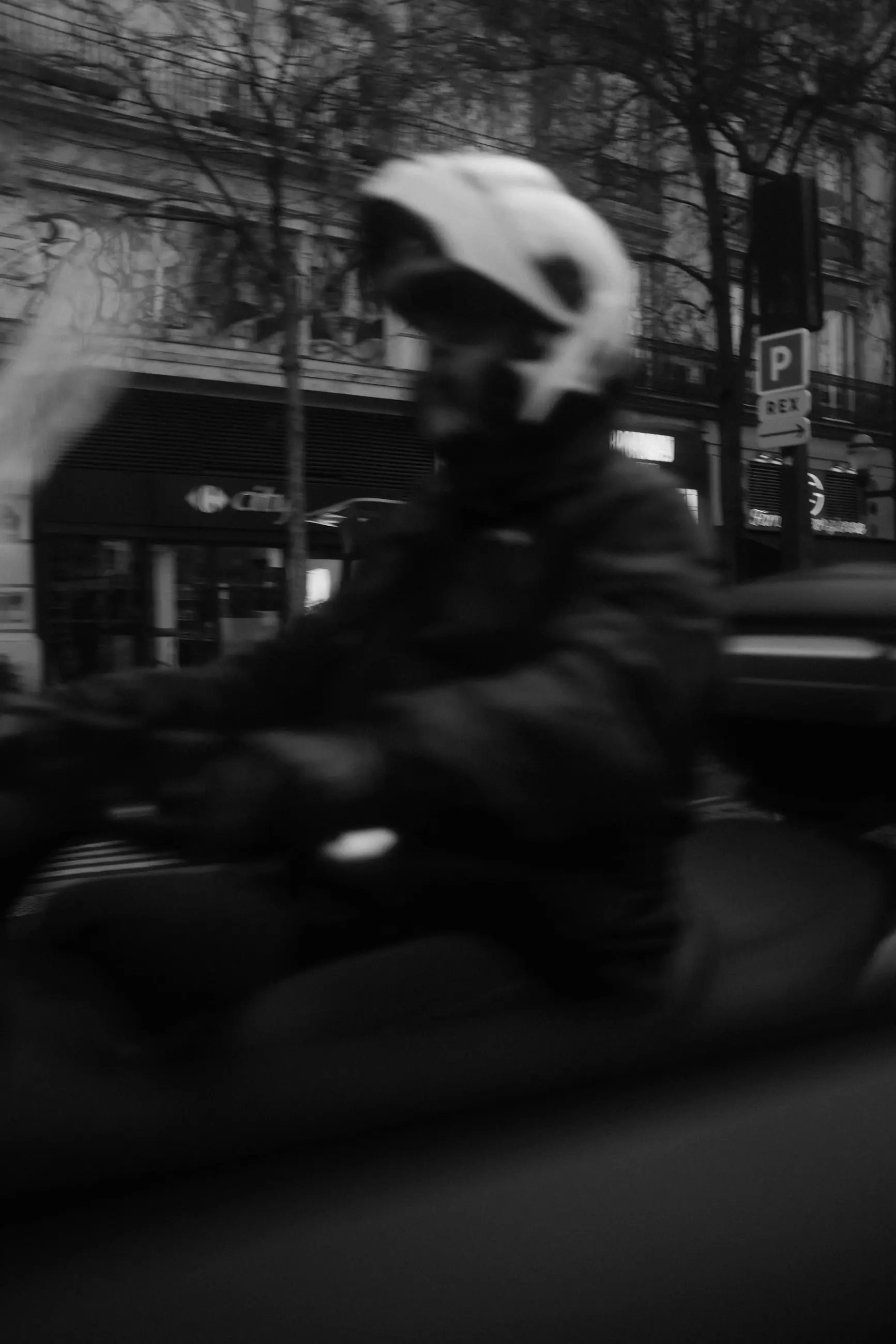 A rider in a white helmet blurred as they pass close to the window