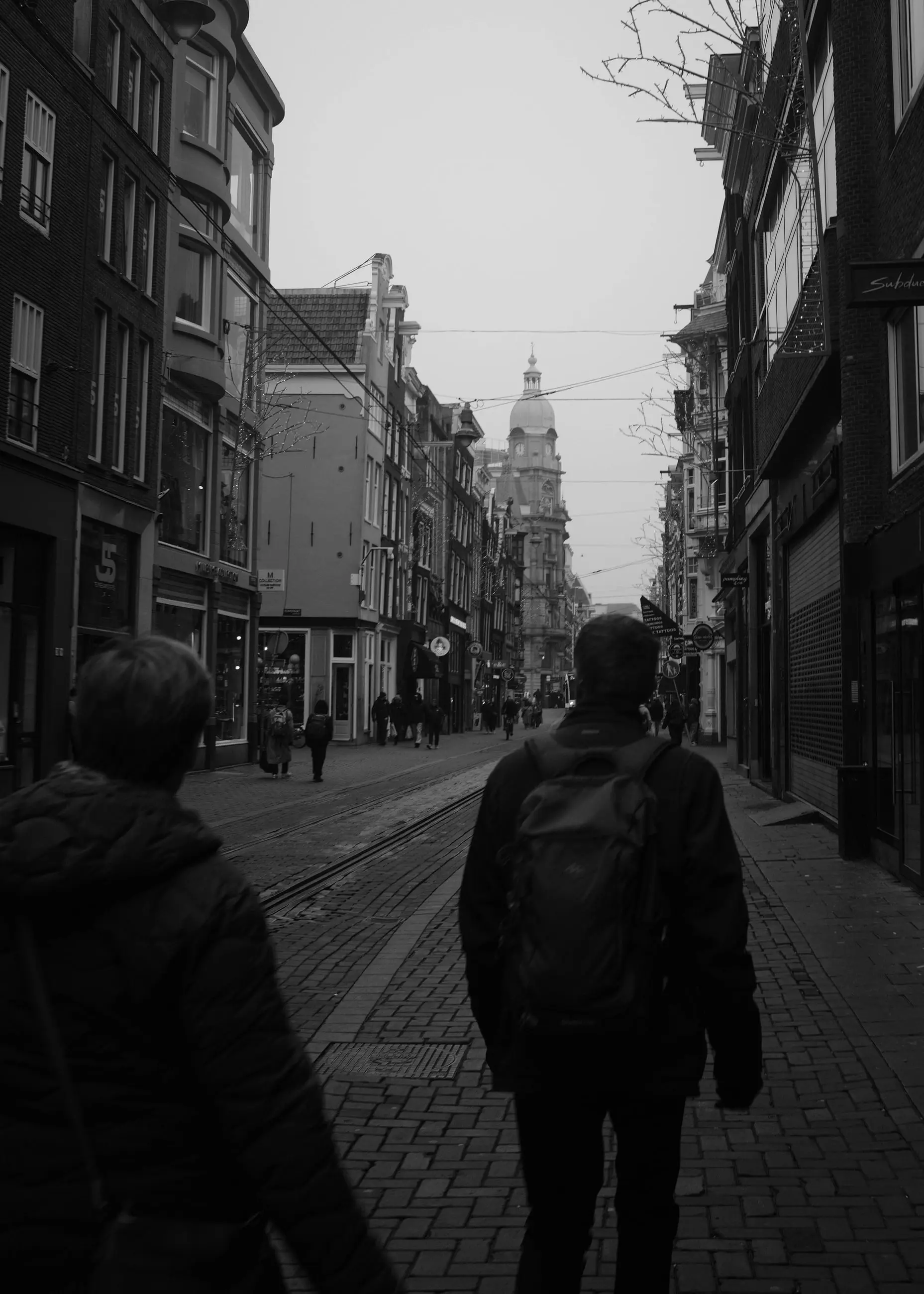 Two pedestrians seen from behind on a cobbled street