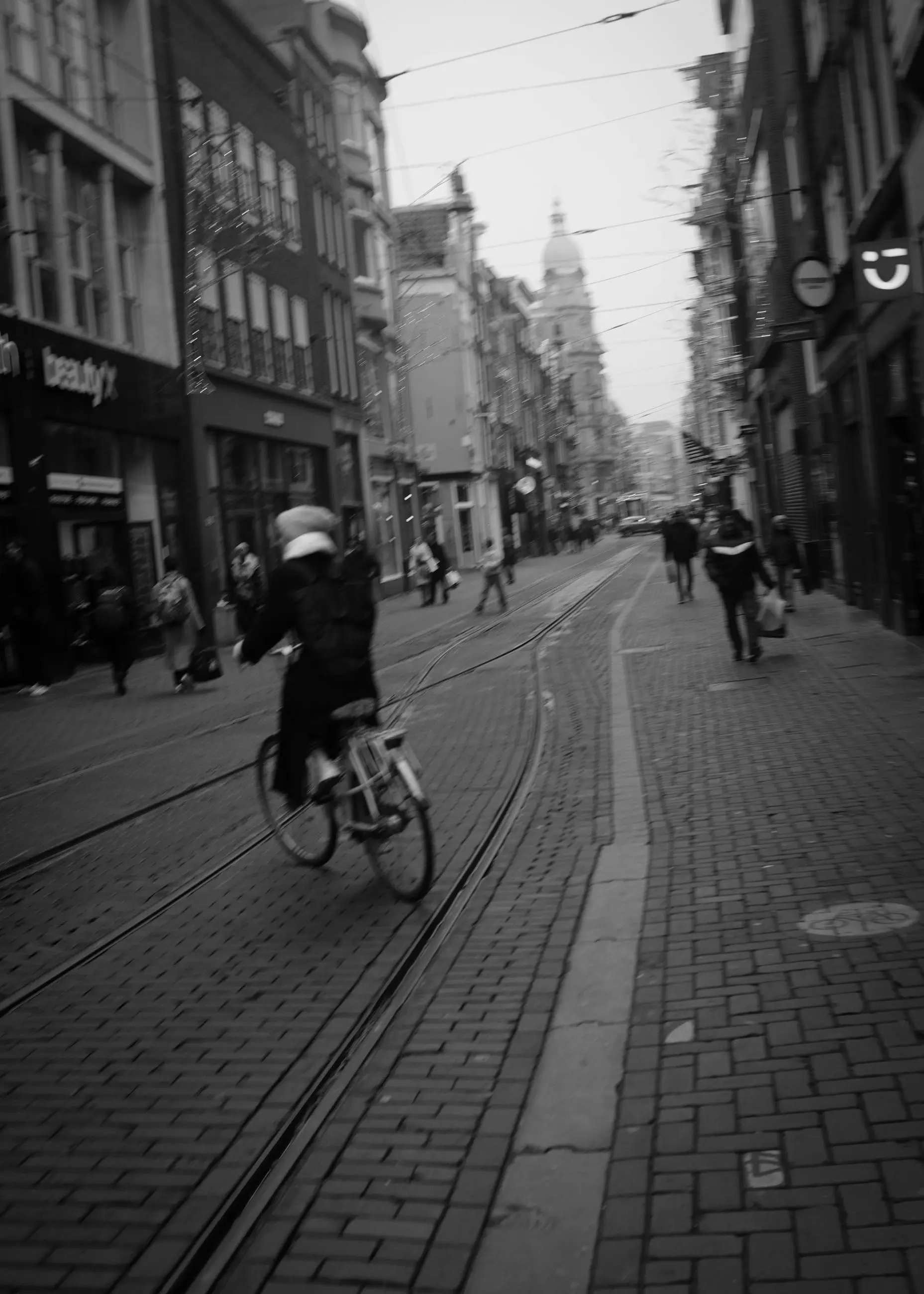 A cyclist on a cobbled street laid with tram tracks