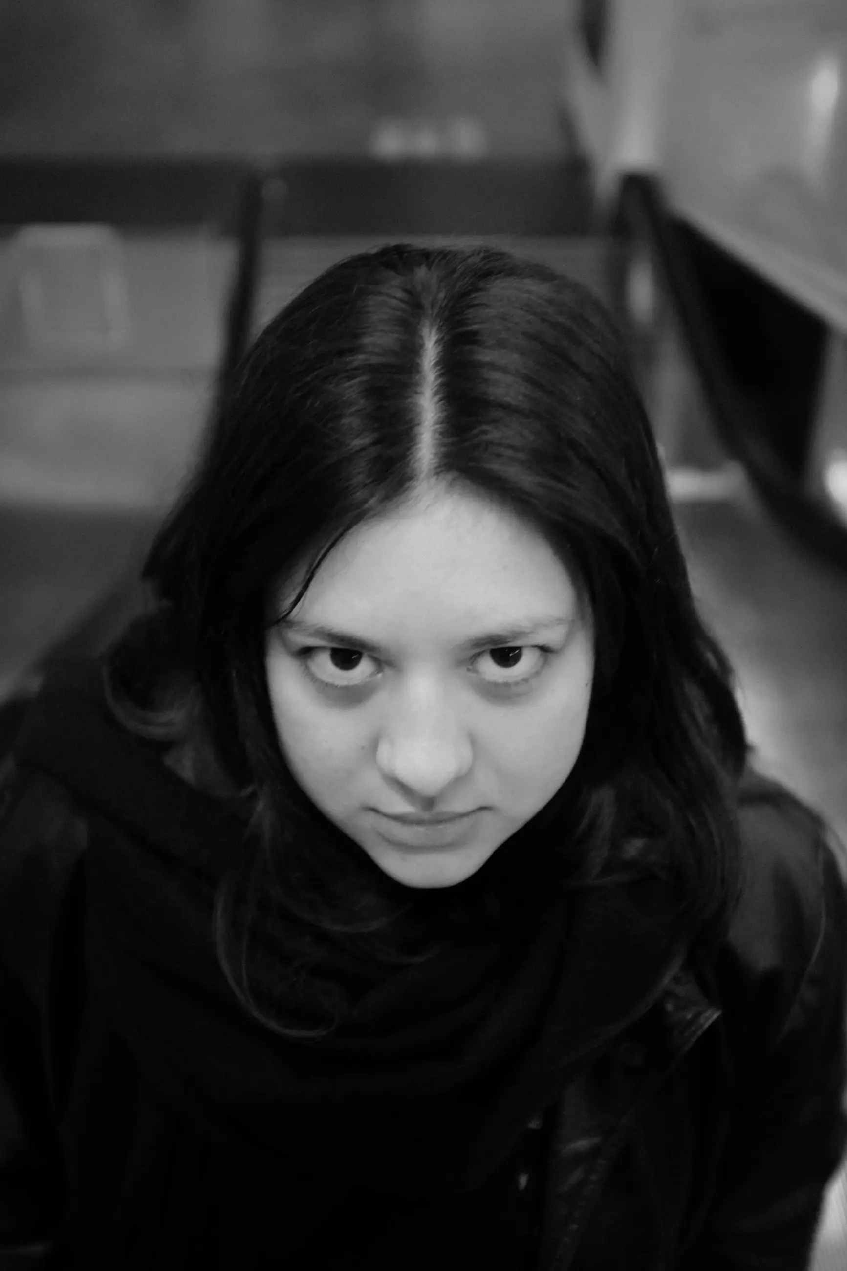 A woman looking up at the camera, seen from above on a stair